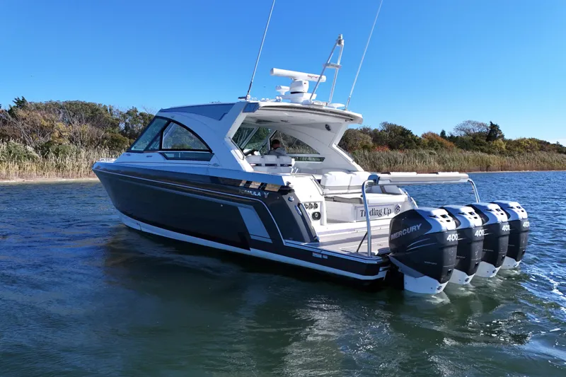 Slide: The Image of 2021 Formula 400 Super Sport Crossover boat on water, featuring four Mercury engines. - 8