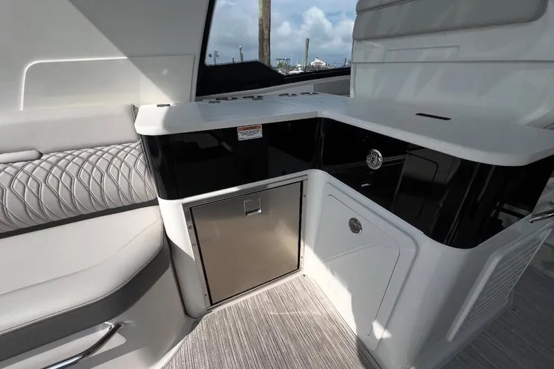 Slide: The Image of 2024 Sea Ray Sundancer 370 dashboard with dual Simrad navigation displays. - 22