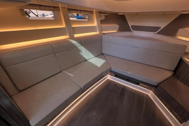 Slide: The Image of 2024 Sea Ray Sundancer 370 with luxurious seating and table, docked at a marina. - 26