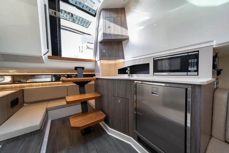 Slide: The Image of 2024 Sea Ray Sundancer 370 interior with modern kitchen and wooden steps. - 31