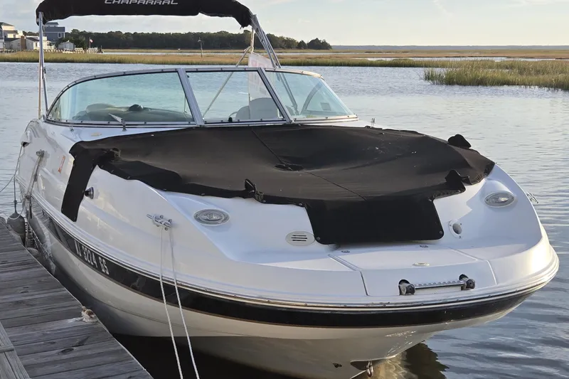Slide: The Image of 2003 Chaparral Sunesta 233 boat docked on calm water, covered and ready for use. - 11