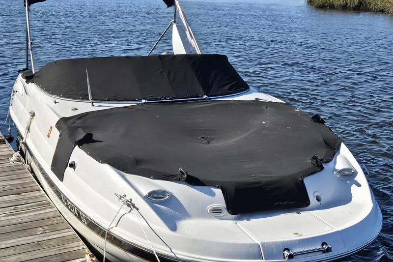 Slide: The Image of 2003 Chaparral Sunesta 233 boat docked with black cover on a sunny day. - 13