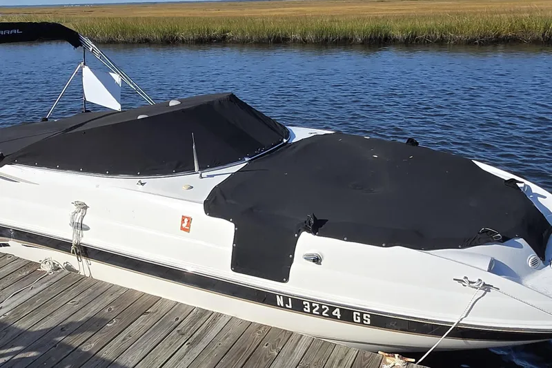 Slide: The Image of 2003 Chaparral Sunesta 233 boat docked by a serene waterway. - 14