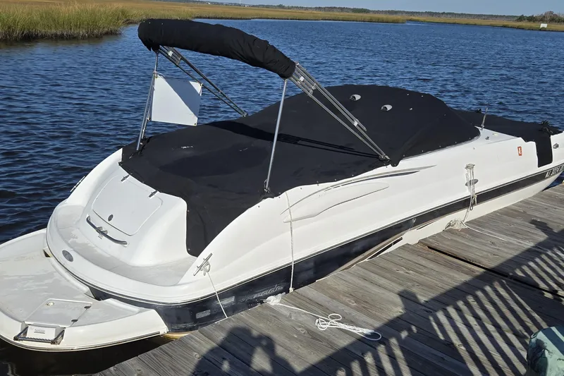Slide: The Image of 2003 Chaparral Sunesta 233 boat docked, covered with black canopy, on a sunny day. - 15