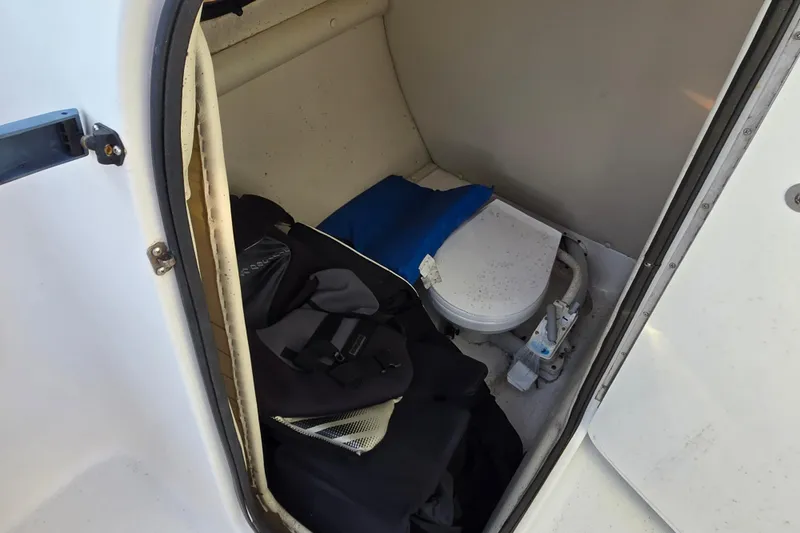 Slide: The Image of 2003 Chaparral Sunesta 233 boat interior with storage and toilet area. - 9