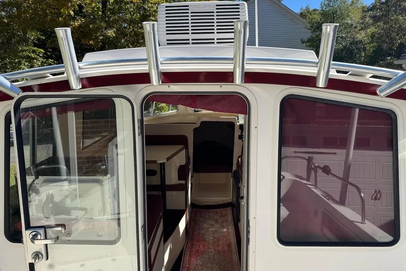 Slide: The Image of 2007 C-Dory 25 Pilothouse boat interior with open door and rod holders. - 12