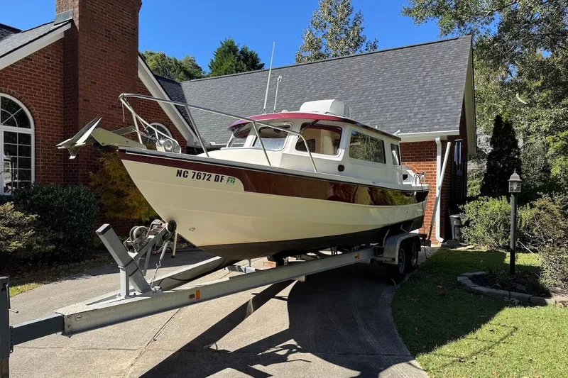 Slide: The Image of 2007 C-Dory 25 Pilothouse boat on trailer in driveway near brick house. - 2