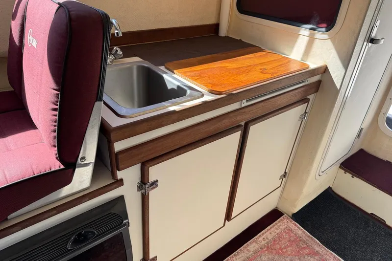 Slide: The Image of Interior of a 2007 C-Dory 25 Pilothouse with sink and wooden countertop. - 21