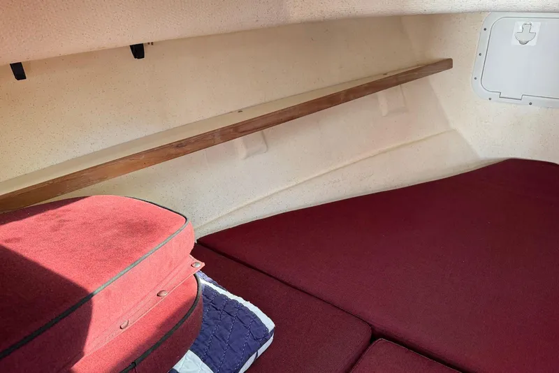 Slide: The Image of Interior cabin of 2007 C-Dory 25 Pilothouse with red cushions and wooden shelf. - 22