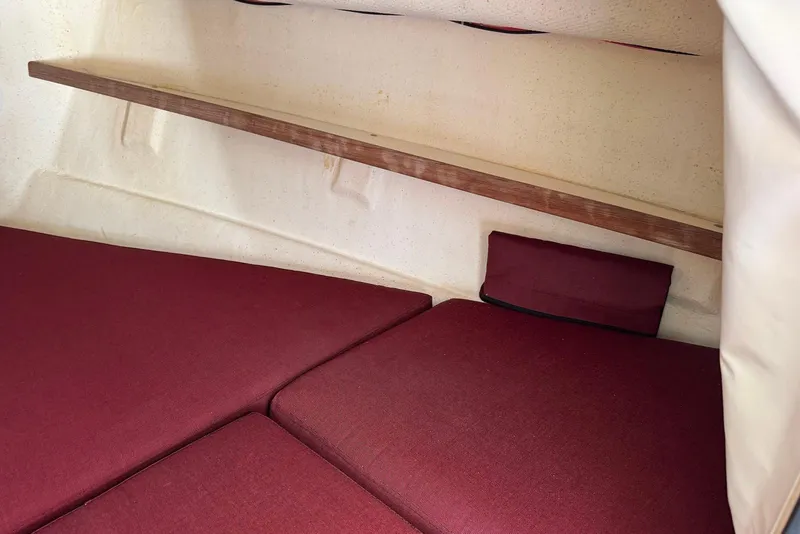 Slide: The Image of Interior cabin of 2007 C-Dory 25 Pilothouse with red cushions and wooden shelf. - 23