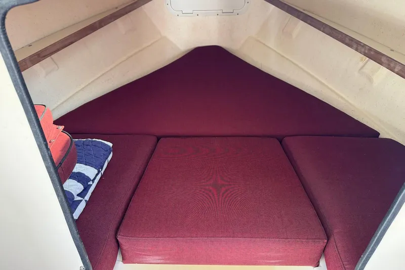 Slide: The Image of 2007 C-Dory 25 Pilothouse interior with red cushions and storage space. - 24