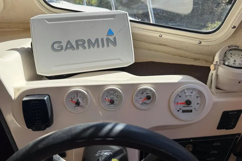Slide: The Image of 2007 C-Dory 25 Pilothouse dashboard with Garmin GPS and Honda gauges. - 26