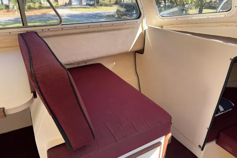 Slide: The Image of Interior of 2007 C-Dory 25 Pilothouse with maroon seating and beige walls. - 29