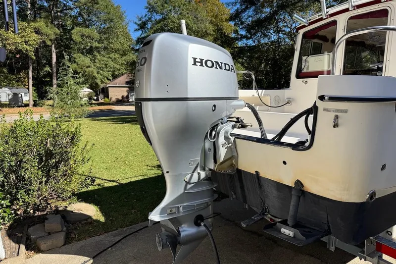 Slide: The Image of 2007 C-Dory 25 Pilothouse with Honda outboard motor in a sunny yard. - 4