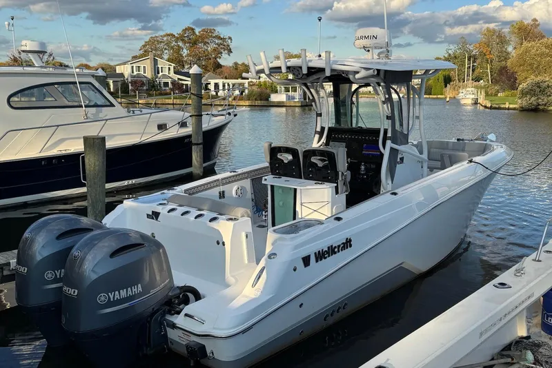 Slide: The Image of 2023 Wellcraft 262 Fisherman boat docked, featuring dual Yamaha engines and modern design. - 1