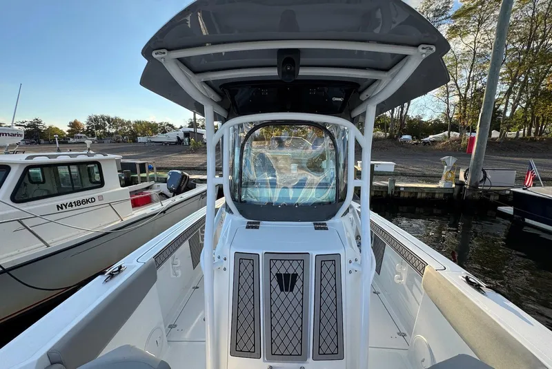 Slide: The Image of 2023 Wellcraft 262 Fisherman boat docked, showcasing helm and seating area. - 12