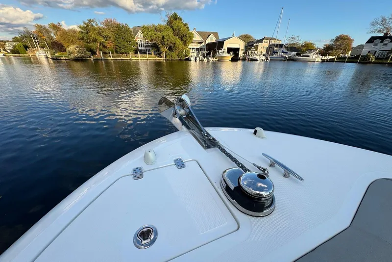 Slide: The Image of Bow of 2023 Wellcraft 262 Fisherman boat on calm water near marina. - 13