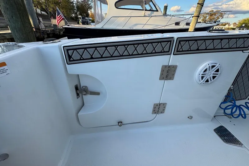 Slide: The Image of 2023 Wellcraft 262 Fisherman boat interior with storage compartment and speaker. - 19