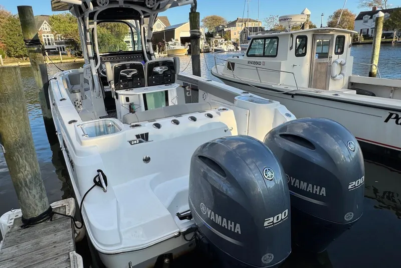 Slide: The Image of 2023 Wellcraft 262 Fisherman boat with dual Yamaha 200 engines docked at marina. - 2