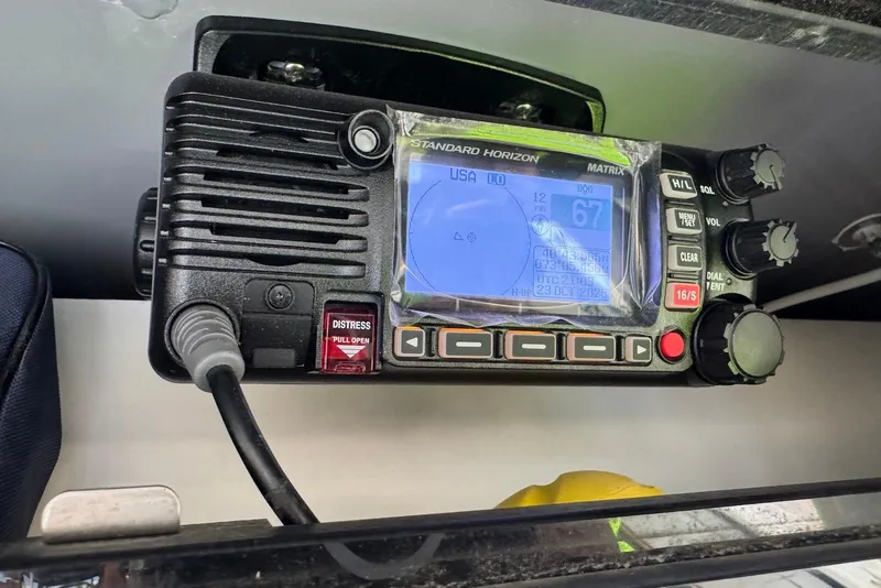 Slide: The Image of Marine radio on 2023 Wellcraft 262 Fisherman boat, displaying coordinates and distress button. - 25