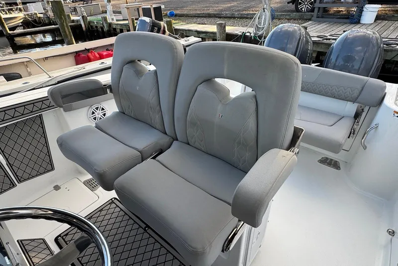Slide: The Image of 2023 Wellcraft 262 Fisherman boat interior with plush seating and dual outboard motors. - 26
