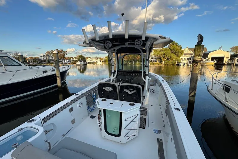 Slide: The Image of 2023 Wellcraft 262 Fisherman boat docked in a scenic marina under a blue sky. - 27