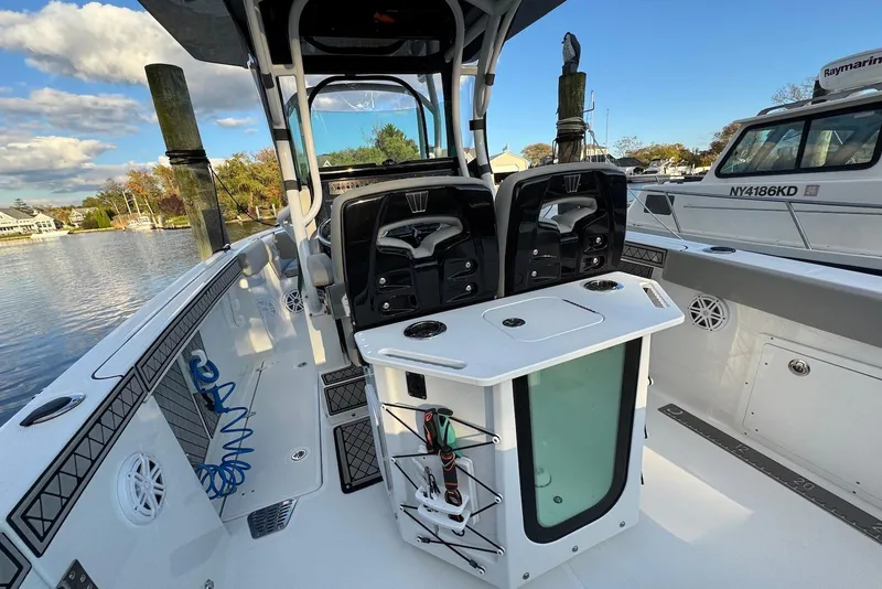 Slide: The Image of 2023 Wellcraft 262 Fisherman boat interior with seating and fishing equipment, docked by the water. - 7