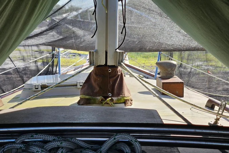 Slide: The Image of 1988 Bayfield 32C sailboat deck with ropes and winch, under protective cover. - 10