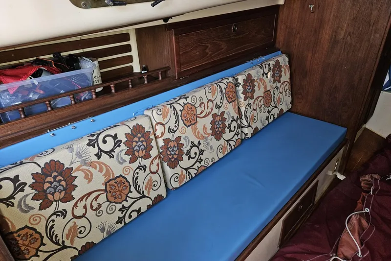 Slide: The Image of Interior of a 1988 Bayfield 32C sailboat with floral-patterned cushions and blue seating. - 27