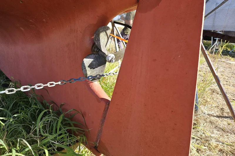 Slide: The Image of 1988 Bayfield 32C sailboat propeller and rudder, grounded on grass. - 28
