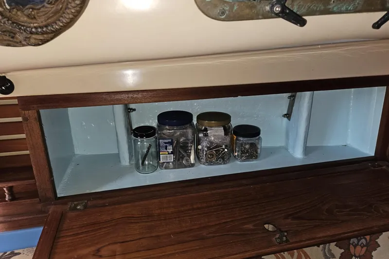Slide: The Image of Storage compartment on a 1988 Bayfield 32C boat with jars of hardware. - 35