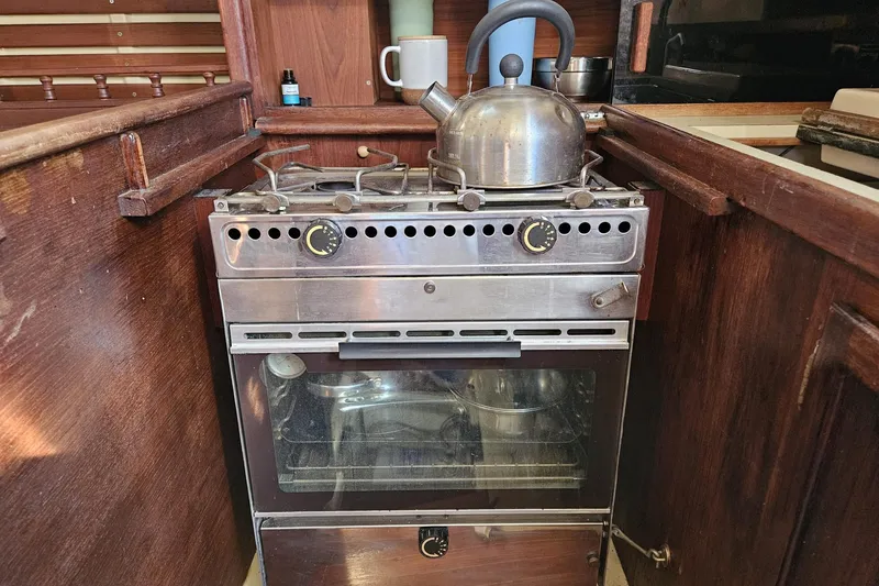 Slide: The Image of Compact kitchen stove with kettle in a 1988 Bayfield 32C sailboat galley. - 38