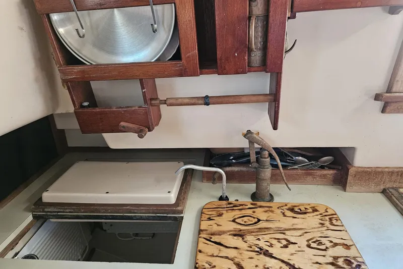 Slide: The Image of 1988 Bayfield 32C yacht kitchen with wooden cabinetry, sink, and utensils. - 39