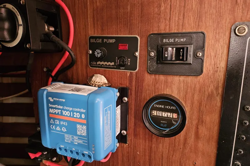 Slide: The Image of Control panel of a 1988 Bayfield 32C with bilge pump switches and solar charge controller. - 42