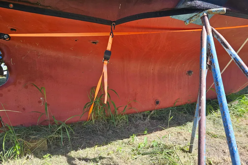 Slide: The Image of 1988 Bayfield 32C sailboat on stands, covered with netting, surrounded by palm trees. - 5