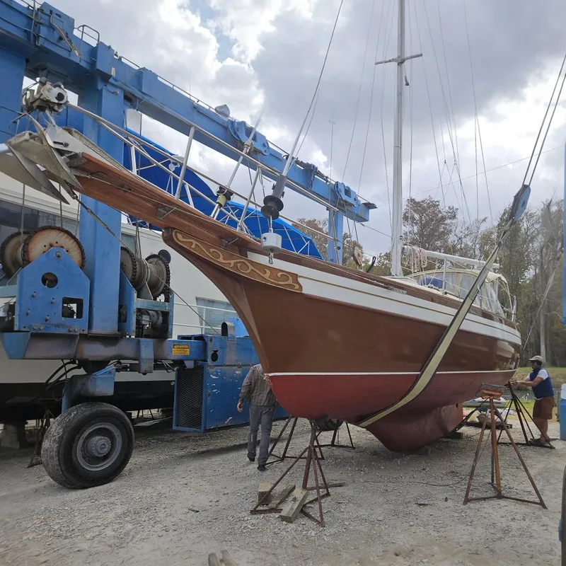Slide: The Image of 1988 Bayfield 32C sailboat in dry dock, supported by stands and a crane. - 0