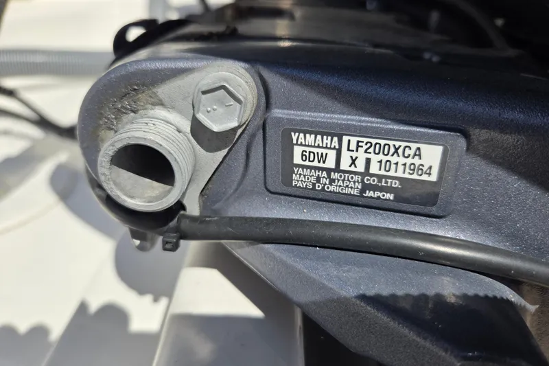 Slide: The Image of 2022 Pursuit S 268 Sport boat interior with seating and storage, docked by the water. - 7