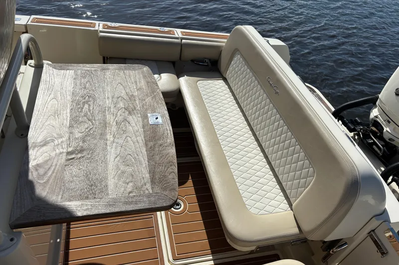 Slide: The Image of 2018 Chris-Craft Catalina 30 boat interior with cushioned seating and wooden table. - 11