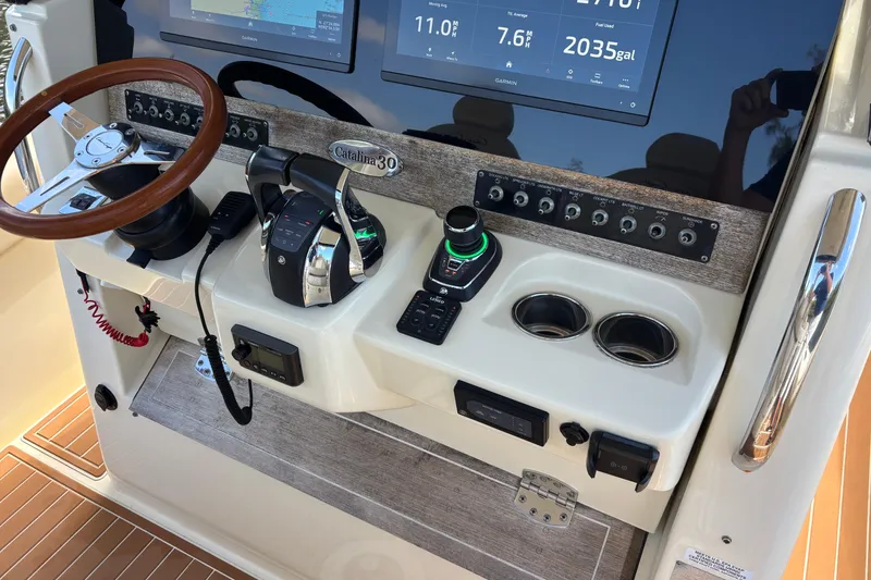 Slide: The Image of 2018 Chris-Craft Catalina 30 helm with steering wheel, controls, and navigation displays. - 13