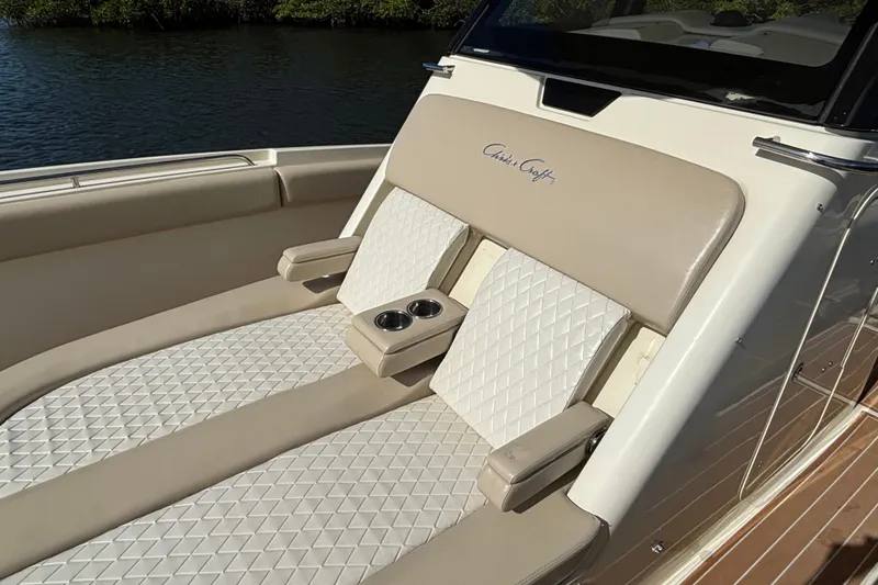 Slide: The Image of 2018 Chris-Craft Catalina 30 boat seating with beige and white upholstery, featuring cup holders. - 15