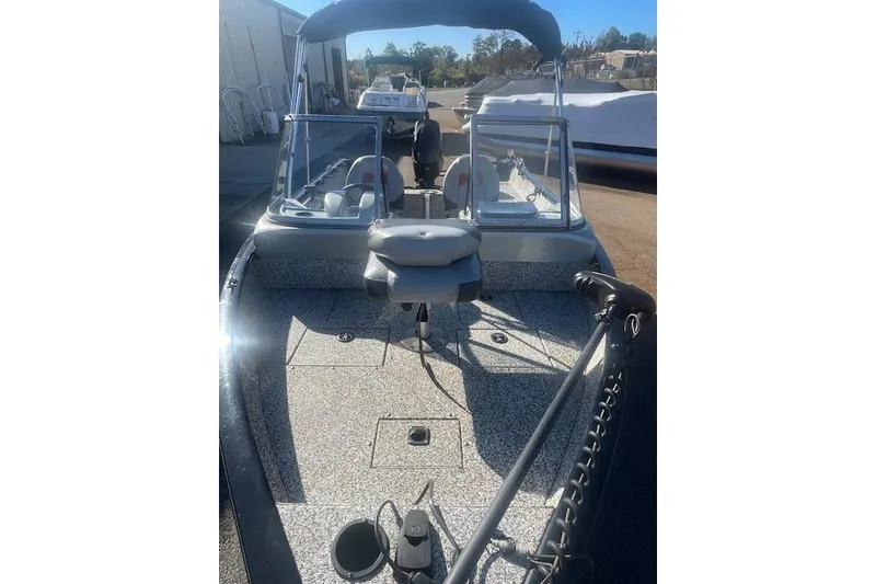 Slide: The Image of 2016 Tracker Pro Guide V-16 WT boat with seating and windshield, parked outdoors. - 4