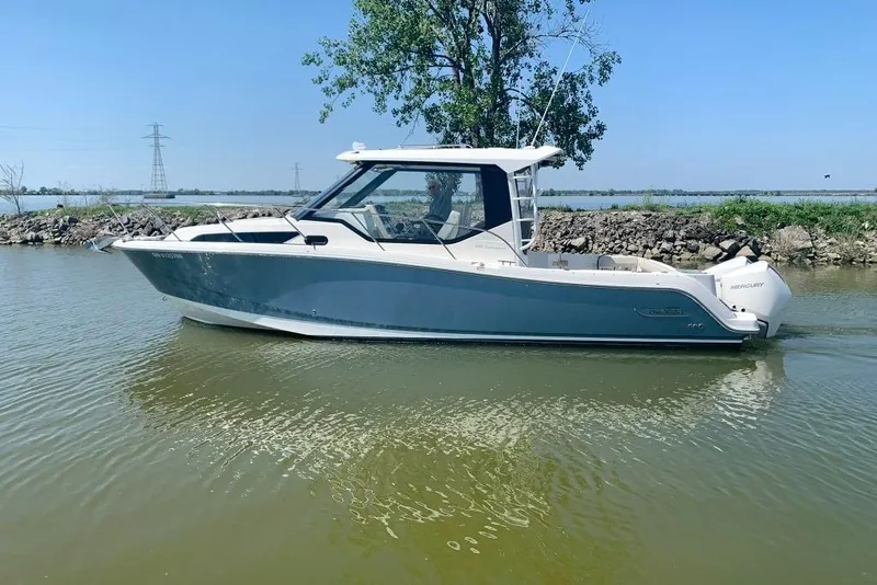 The Image of 2022 Boston Whaler 325 Conquest boat on calm water, clear sky background. - 0