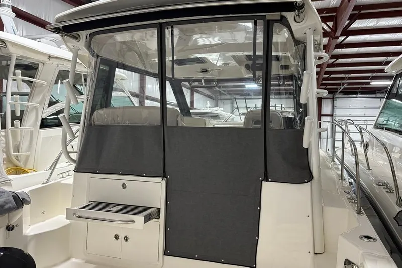 Slide: The Image of 2022 Boston Whaler 325 Conquest boat interior with covered seating and storage. - 10