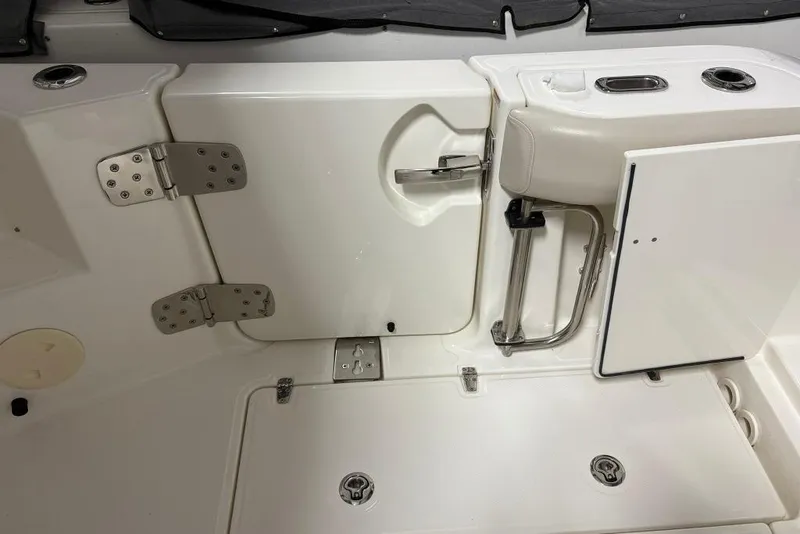 Slide: The Image of 2022 Boston Whaler 325 Conquest boat interior, featuring white seating and storage compartments. - 12