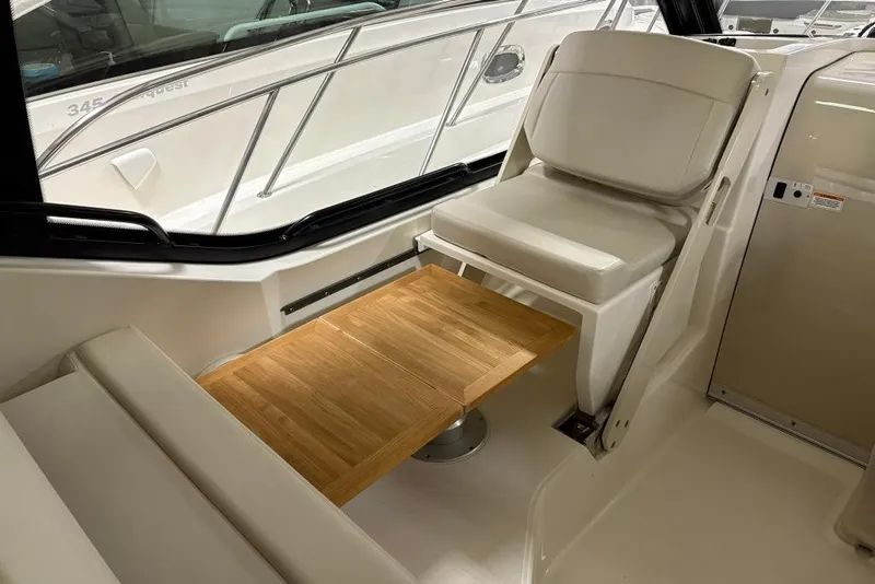 Slide: The Image of Interior of 2022 Boston Whaler 325 Conquest with seating and wooden table. - 13