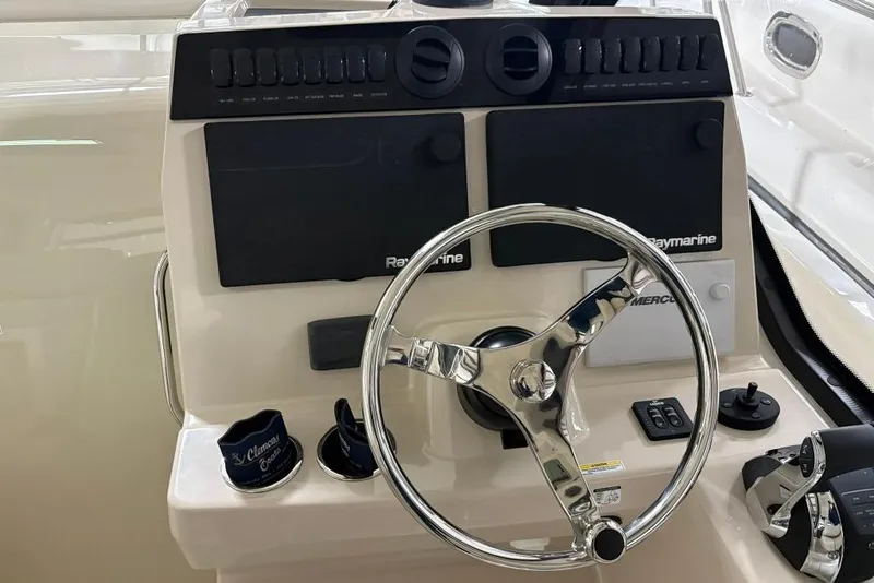 Slide: The Image of 2022 Boston Whaler 325 Conquest helm with steering wheel and Raymarine controls. - 16