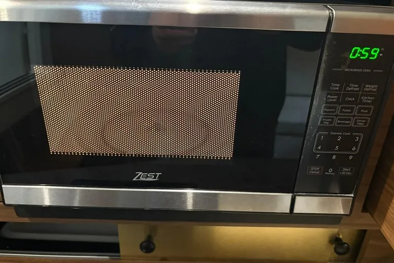Slide: The Image of Microwave oven with digital timer at 59 seconds, featuring Zest branding. - 26
