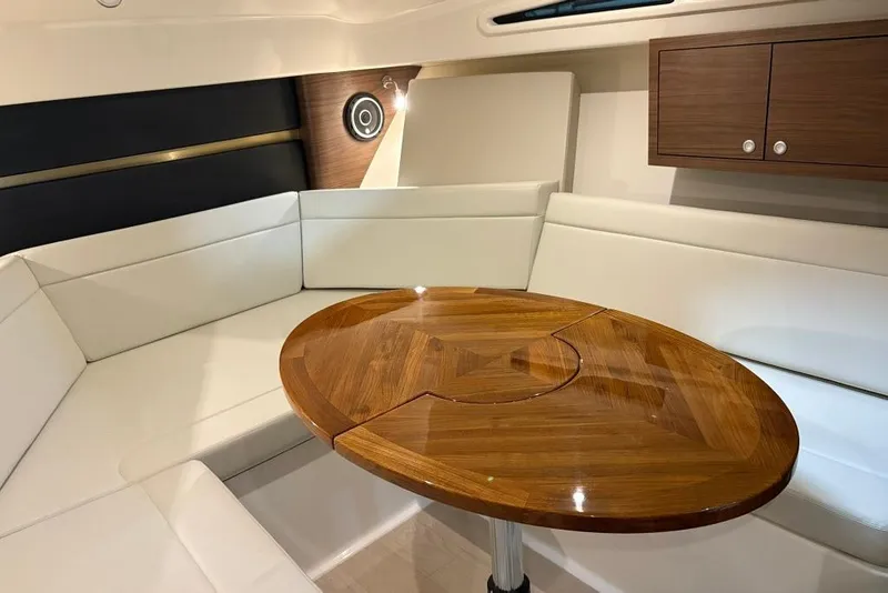 Slide: The Image of Interior of 2022 Boston Whaler 325 Conquest with white seating and wooden table. - 30