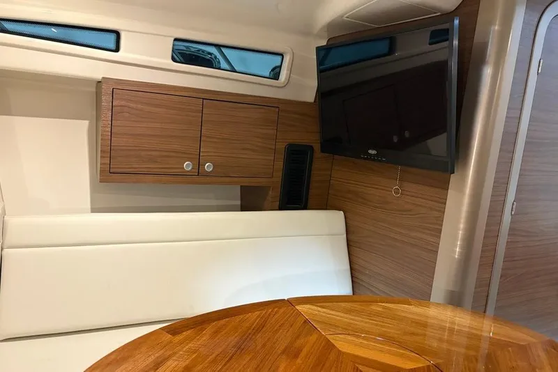 Slide: The Image of Interior of 2022 Boston Whaler 325 Conquest, featuring wood cabinetry and a mounted TV. - 31