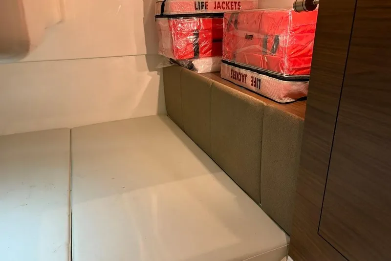 Slide: The Image of Interior of 2022 Boston Whaler 325 Conquest with life jackets stored on cushioned seating. - 34